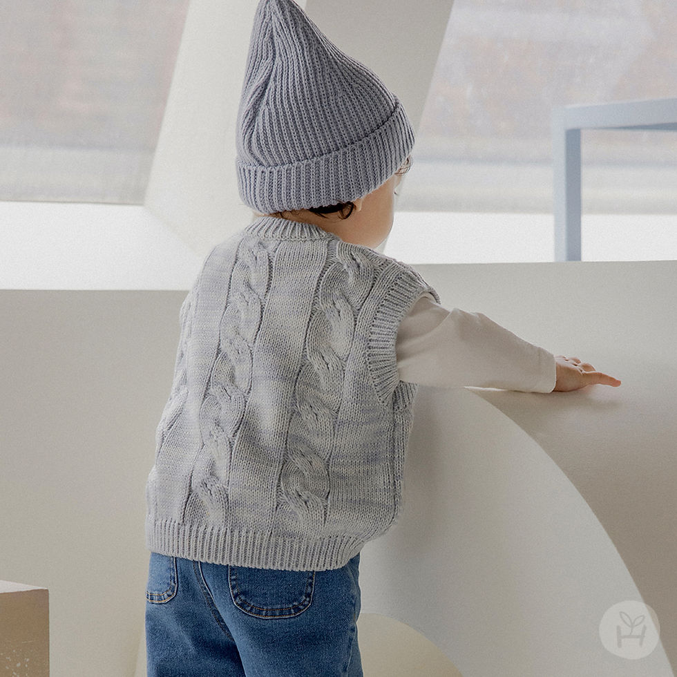 Thumbnail: The Merlin Knit Baby Vest is designed in a loose, oversized style that suits both boys and girls. Made from soft acrylic, thi
