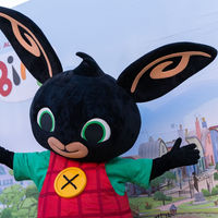 Bing mascotte poseert voor een banner om op de foto te gaan met kinderen op een kermis