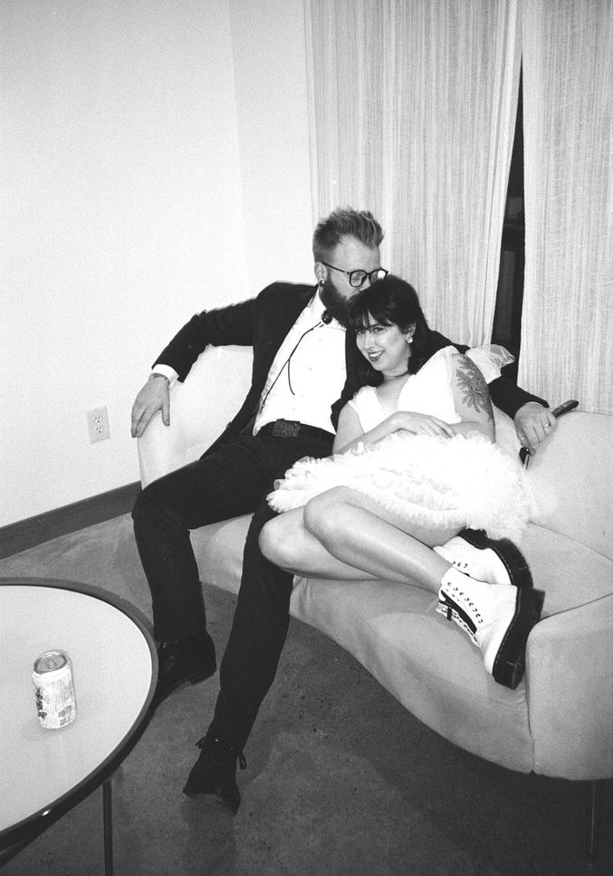 Texas wedding photographer photographing a Black and white film photo of bride and groom cuddling on a couch at their private elopement at The Oak Atelier in Houston, Texas