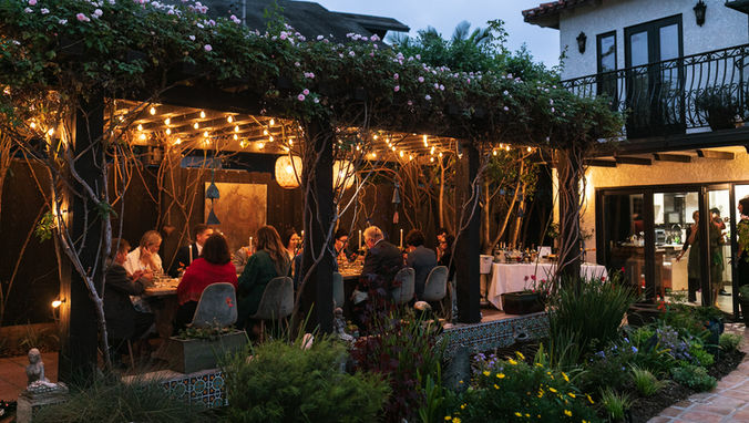 California wedding photographer photographing small intimate dinner reception underneath an arbor of greenery at Villa Francesca in La Jolla, California