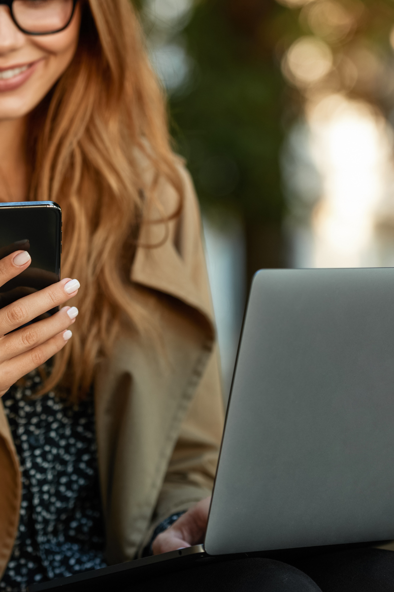 Cosmetologist reading emails on laptop and cell phone