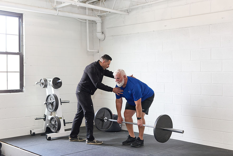 An older man performs a deadlift. Personal Training.