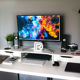 a large home desk with a futuristic monitor on it