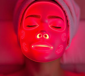the face of a woman using a red-light therapy mask