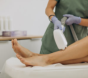 a woman using a laser hair removal device on her leg