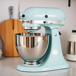 a white stand mixer with a steel bowl