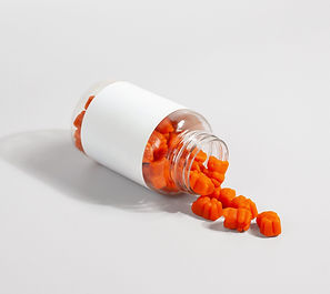 a pill bottle with red vitamins poured out