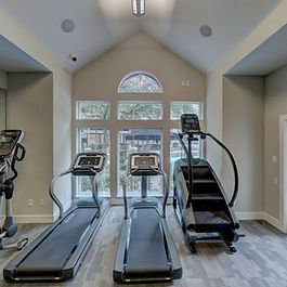 a windowed room with three treadmills