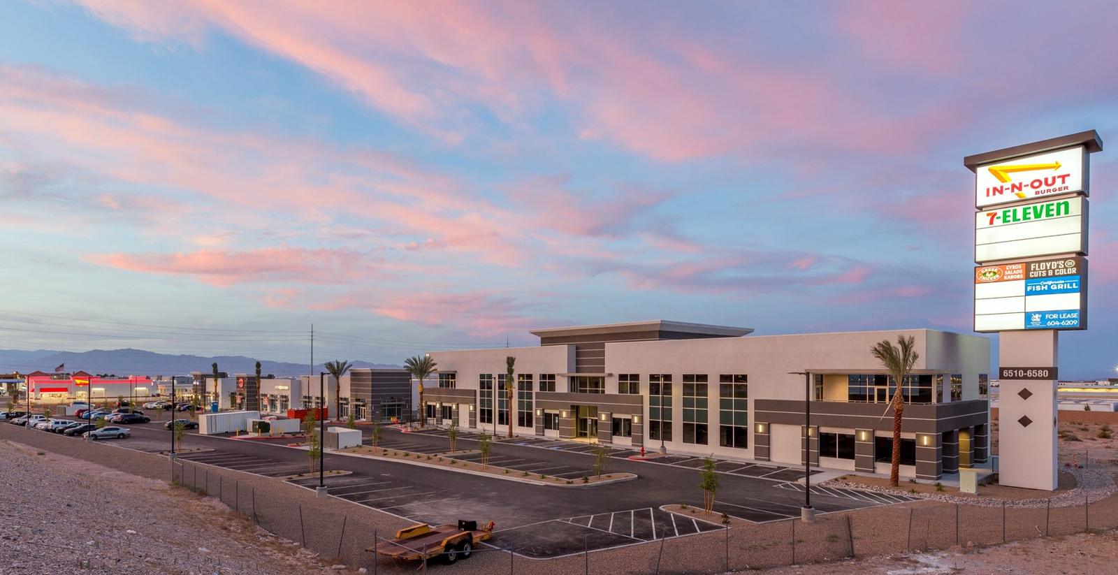 Rainbow Commons retail buildings and pylon sign at dusk, ground-up commercial construction, Las Vegas