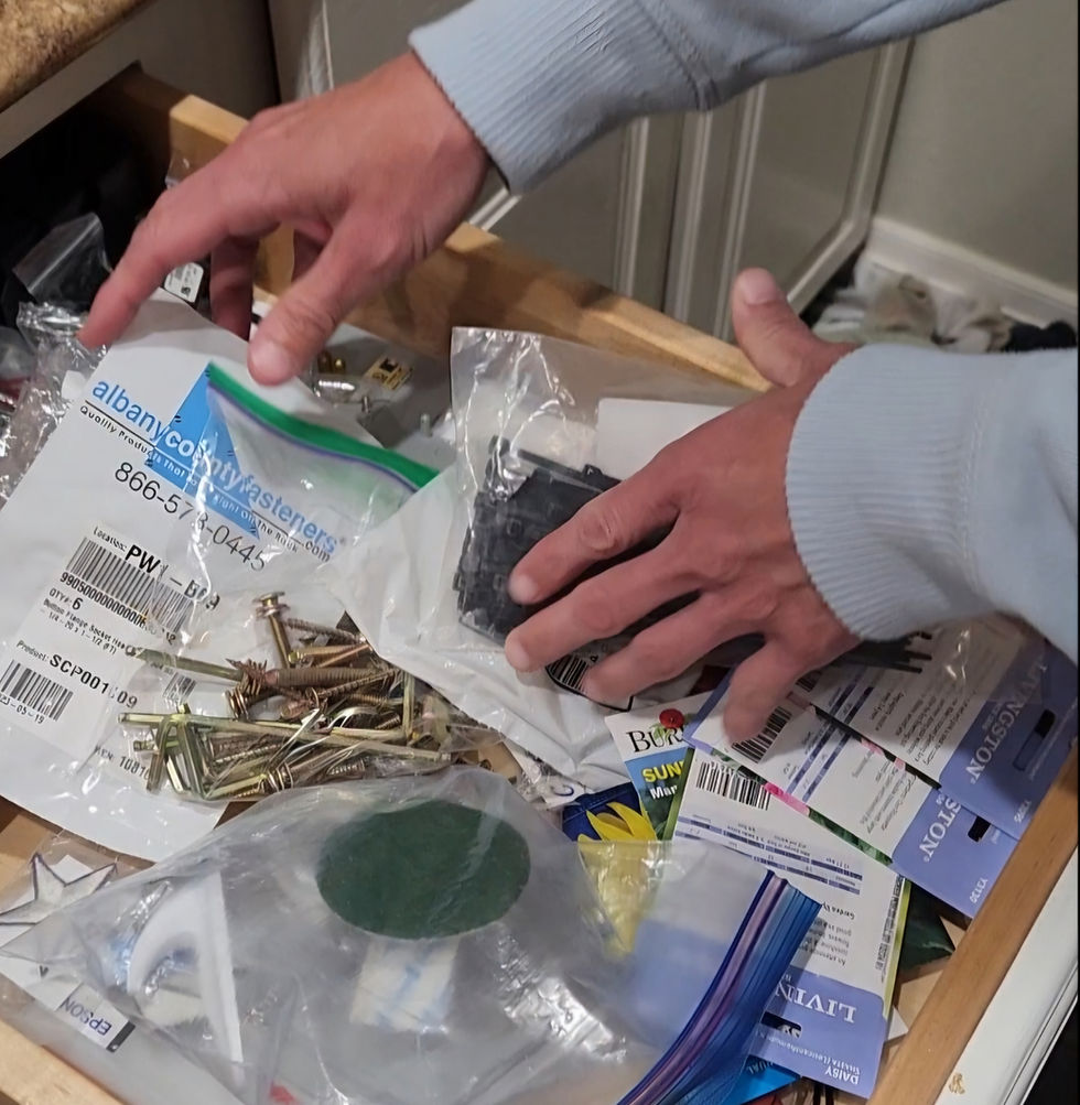 Photo of two hands rifling through a junk drawer.