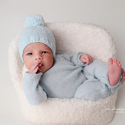 Nou-născut înfășat albastru cu căciuliță asortată, decor minimalist studio foto bebeluși București