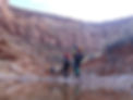 An image of three people with backpacks, walking through a canyon in Utah.