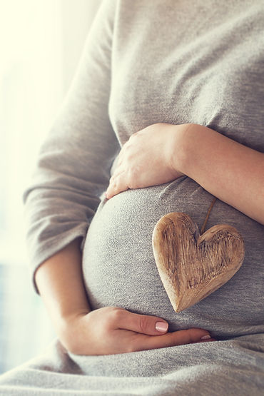 pregnant-woman-holding-heart-while-touching-her-belly.jpg