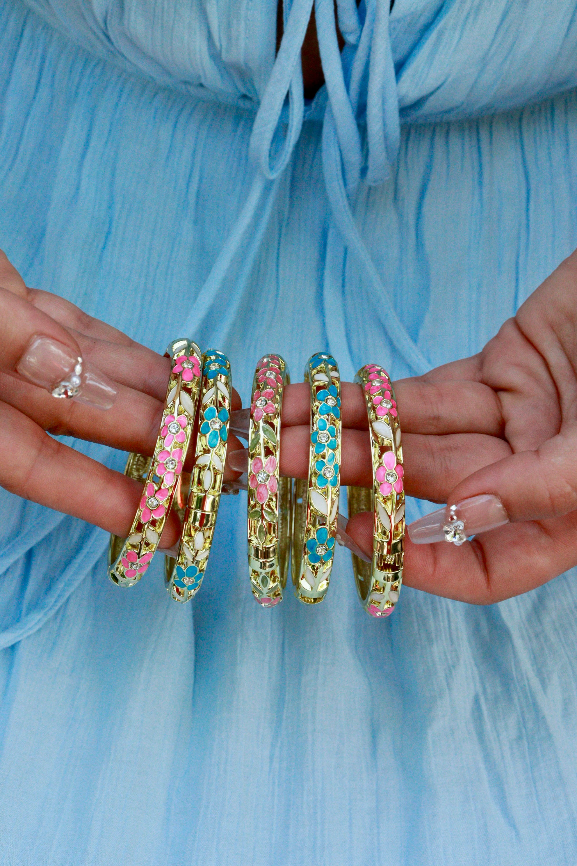 Joncs colorés en métal doré et émail, motifs floraux rose ou bleu, fermoir à charnière