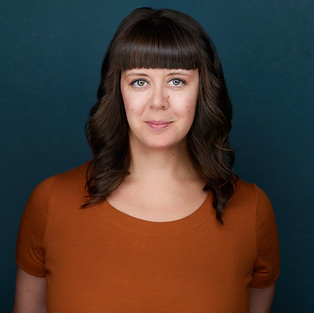 Headshot of a smiling woman with shoulder-length brown hair.