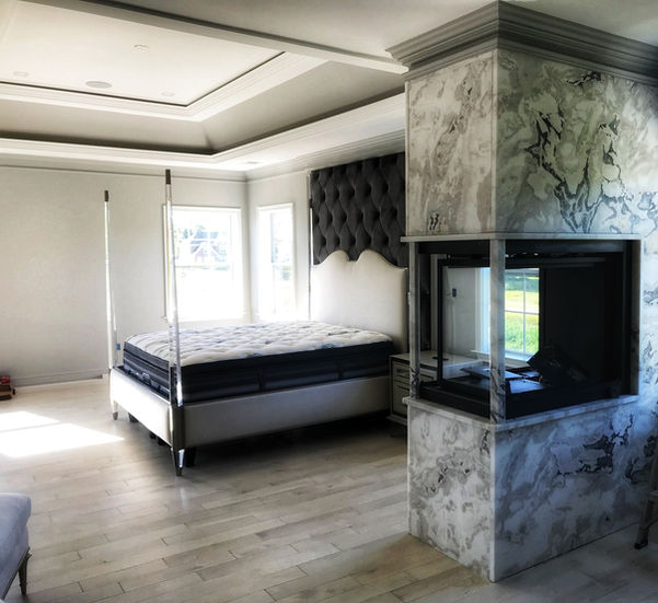 Cozy bedroom with upholstered bed and tray ceiling