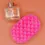 Thumbnail: Pink Alienne Exfoliating Soap Sponge next to a clear perfume bottle with peach background
