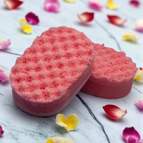 Two Pinky Orange Lust Soap Sponge surrounded by red pink and yellow petals