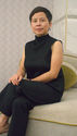 A chinese woman sits in a white room