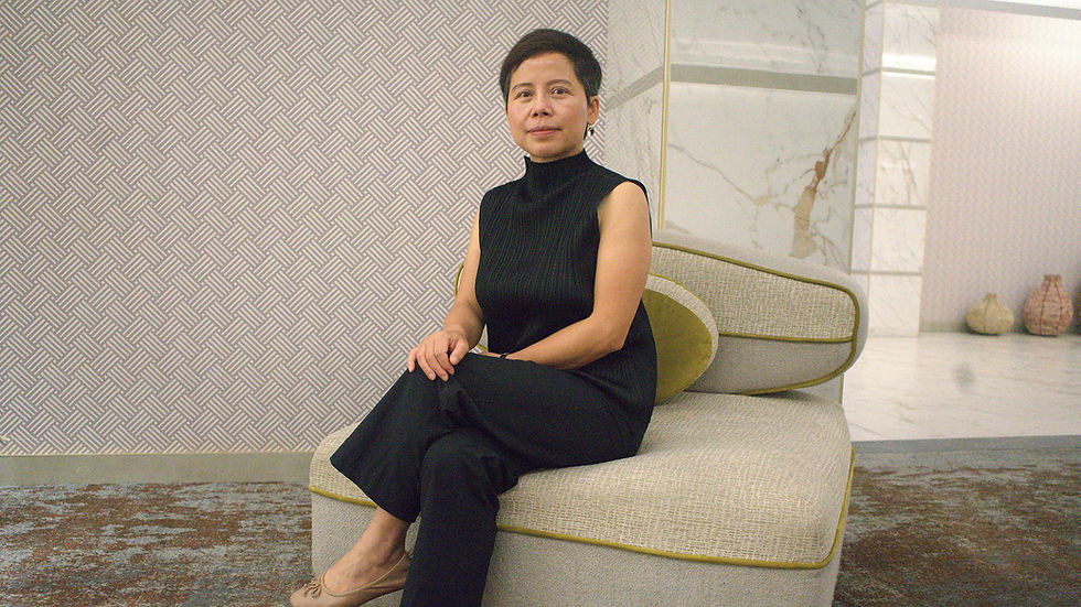 A chinese woman sits in a white room