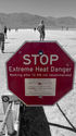 People walking past a red octagonal sign writing "STOP Extreme Heat Danger Walking after 10 AM not recommended"