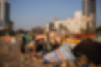 Fishermen with their gear on the beach, with high-rises behind them