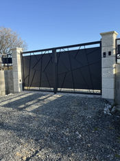 Portail en métal design avec une clôture sur un muret.