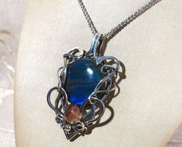 Pingente artesanal em prata 950, elaborado com as poderosas pedras naturais Labradorita e Lodolita, unindo beleza, proteção e profunda energia espiritual.