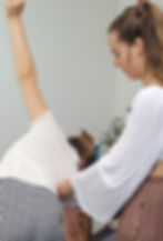 Camille Gasparini, professeure de hatha Yoga en train de corriger la posture d'une élève.