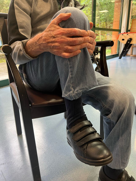 Photographie d'un homme âgé réalisant une posture d'assouplissement du genou.