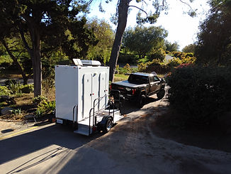 exterior photo of movingstars motorhomes portable restroom trailers out on the job. attached to a GMC truck.