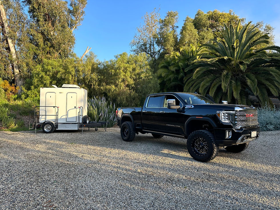 wide view of truck vehicle loading portable trailer bathrooms