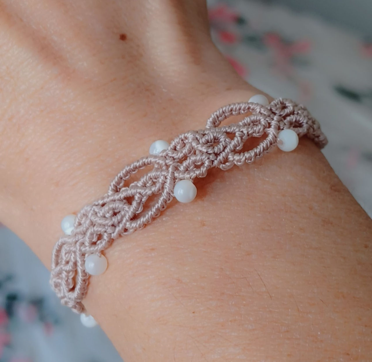 Bijou artisanal en micro-macramé avec perles en nacre, illustrant les tendances couleurs mode automne hiver 2025 2026