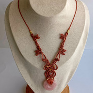 Bijou fait main en micro-macramé avec donut en quartz rose, illustrant les tendances couleurs mode automne hiver 2025 2026.