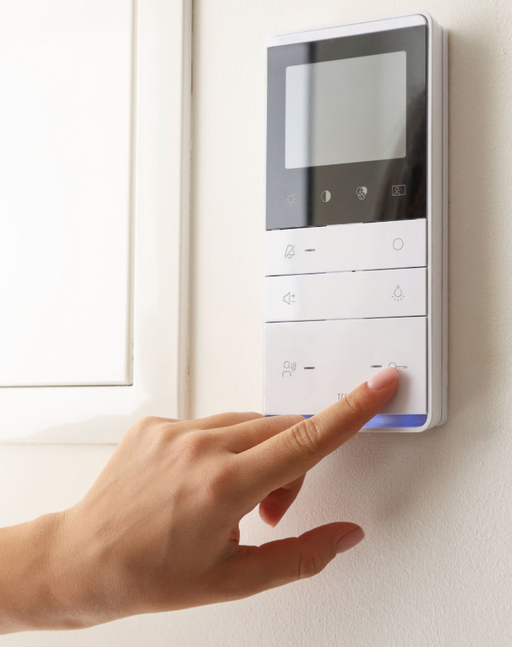 a smart thermostat being pushed by a human hand
