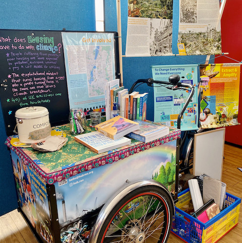 hubRen's cargo bike display all set up, with posters, books, colourful tablecloth