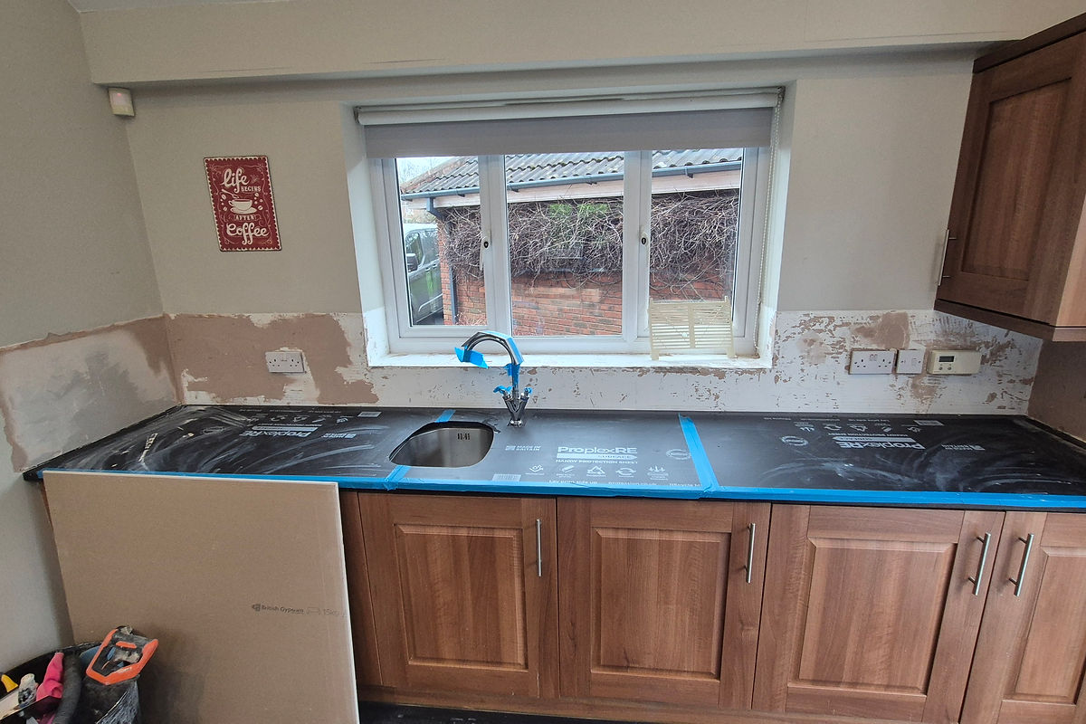 Kitchen wall showing prep when tiles removed ready for retiling, Warrington