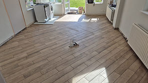 Wood-effect porcelain plank floor tiling installation in Stockton Heath open-plan kitchen and living area