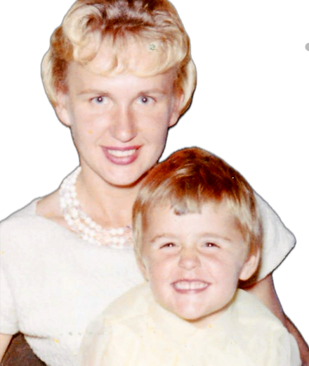 Young 4 year old girl with dirty blonde hair in a light-colored dress sitting on her moms lap with short blonde hair