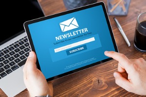 Hands holding tablet with newsletter subscribe form