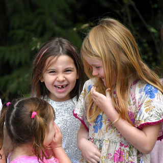 Three girls laughing together outdoors