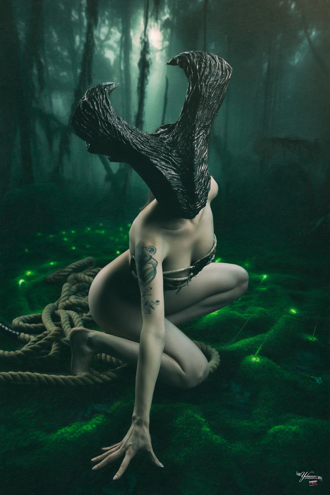 La créature de la forêt une femme nue porte un masque en bois elle est entourée d'une corde par Yes Photographies