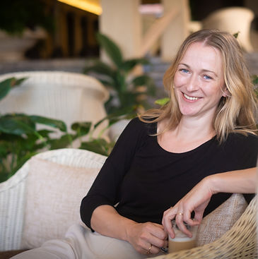 Lisa van LSH Legal, zittend en lachend met een kop koffie in een informele kantooromgeving