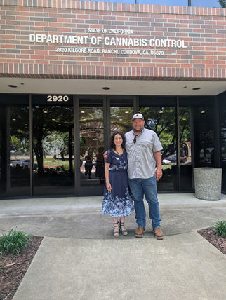 a man and a woman posing for a picture outside of a building