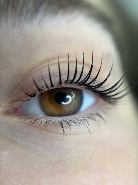 עין נשית עם ריסים ארוכים וירוקים, במבט ממוקד לעבר האופק.
