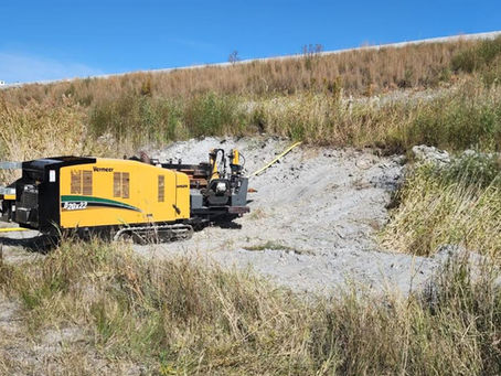 Horizontal directional drilling rig set up on a sloped construction site for trenchless underground installation.