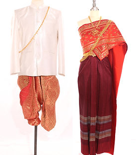 Burgundy and white Thai traditional couple outfit – groom in white jacket with burgundy silk trousers and bride in burgundy silk with white sabai embroidered in gold and green jewel-wing floral patterns, inspired by Golden Mount Kui Cheng architecture.