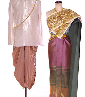 Thai traditional couple outfit – bride in purple nude silk with green accents and gold embroidery, draped with white sabai; groom in green silk ensemble with gold details – elegant Thai wedding attire