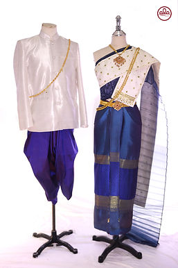 ชุดไทยบ่าวสาวแบบดั้งเดิม สีน้ำเงินเข้มและสีขาว – เจ้าบ่าวสวมจงกระเบนสีน้ำเงินเข้ม เสื้อสูทสีขาว และเจ้าสาวสวมชุดสาไบสีขาว กระโปรงผ้าไหมสีน้ำเงินเข้ม ปักลวดลายสีทอง