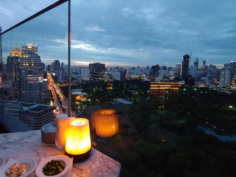 High angle view of a rooftop bar overlooking Bangkok city lights